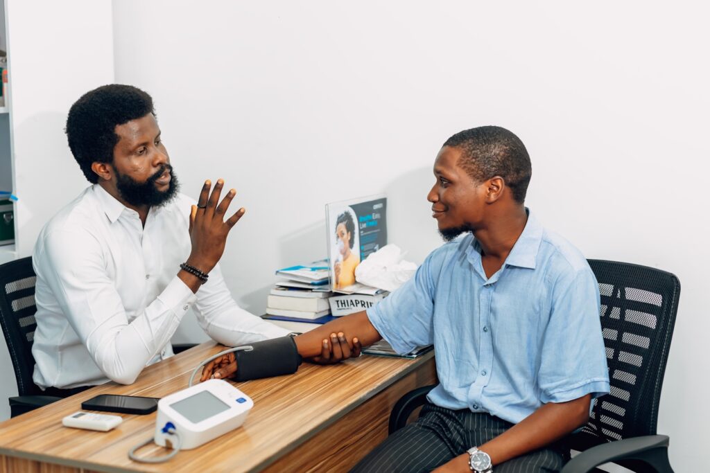 A doctor and patient are sitting across from each other at a desk. Find more afro-centric images at www.ninthgrid.com